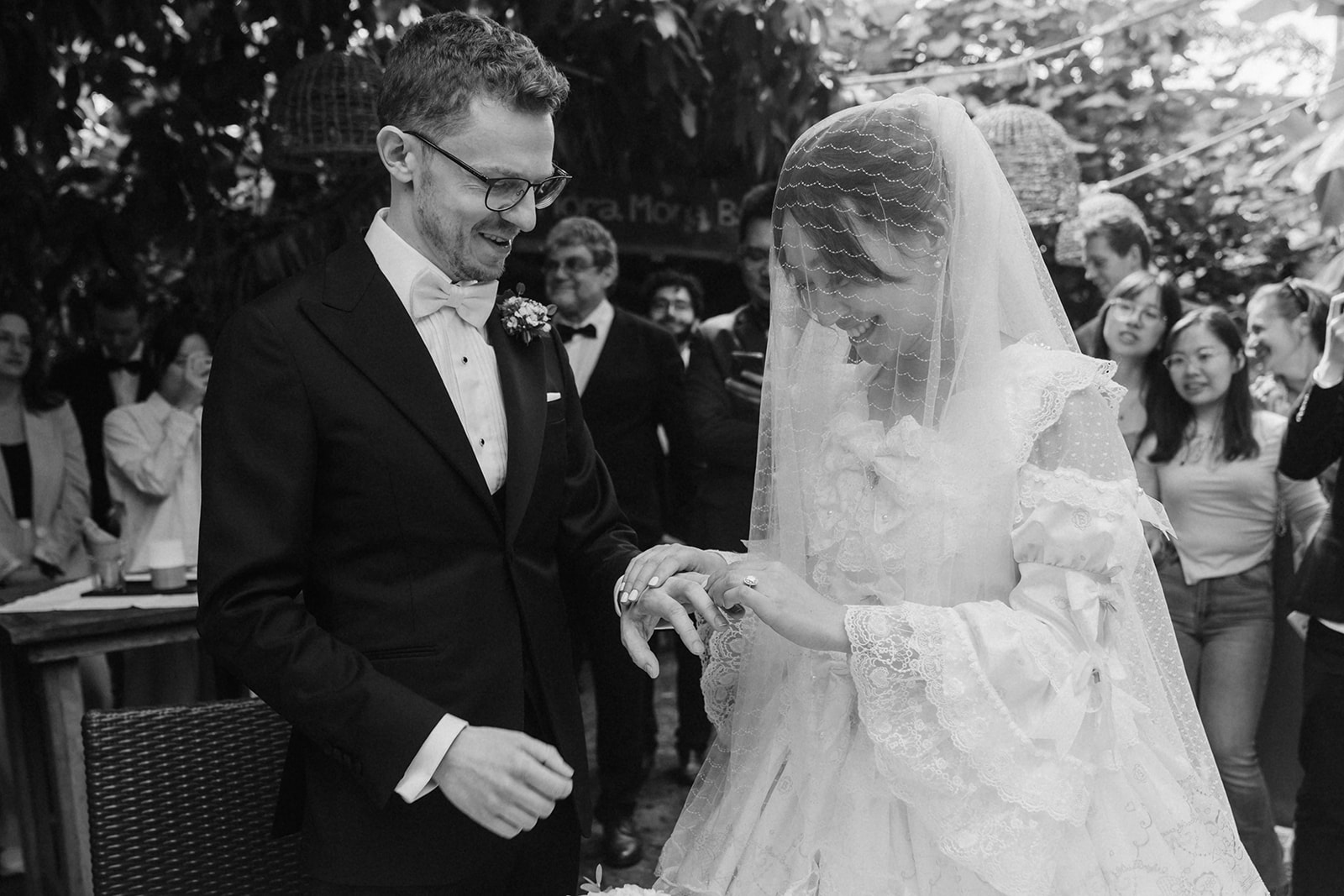 Braut und Bräutigam stecken sich während der Ziviltrauung in der Masoala Halle Zürich gegenseitig die Ringe an, umgeben von Gästen und tropischen Pflanzen.